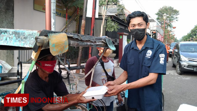Ketua Pokja media Polres Majalengka, Jaja Sumarja membagikan nasi kotak kepada abang becak. (Foto: Humas Polres Majalengka for TIMES Indonesia)