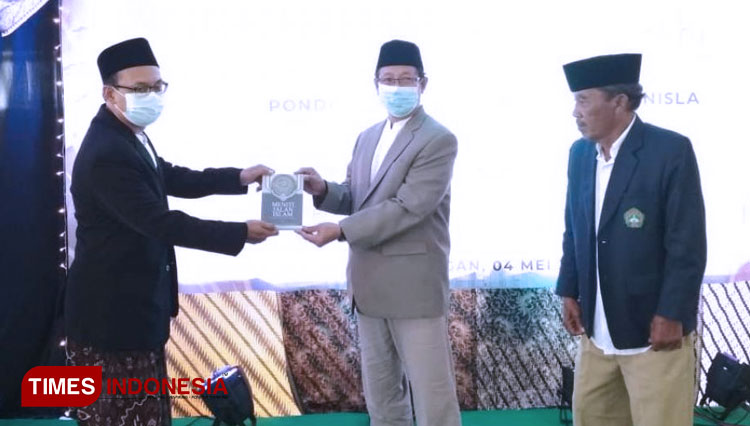 Direktur Ponpesma Unisla (kiri) menyerahkan salah satu buku yang diluncurkan oleh Ponpesma Unisla kepada Rektor Unisla (tengah) saat pelaksanaan wisuda angkatan 24 di Auditorium Pascasarjana Unisla, Selasa, (4/5/2021). (FOTO: AJP TIMES Indonesia)
