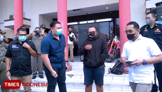 Pria yang sebut pengunjung mall bermasker t*l*l, (tengah jaket hitam) saat diamankan Polrestabes Surabaya, Selasa (4/5/2021). (Foto: Khusnul Hasana/TIMES Indonesia). 