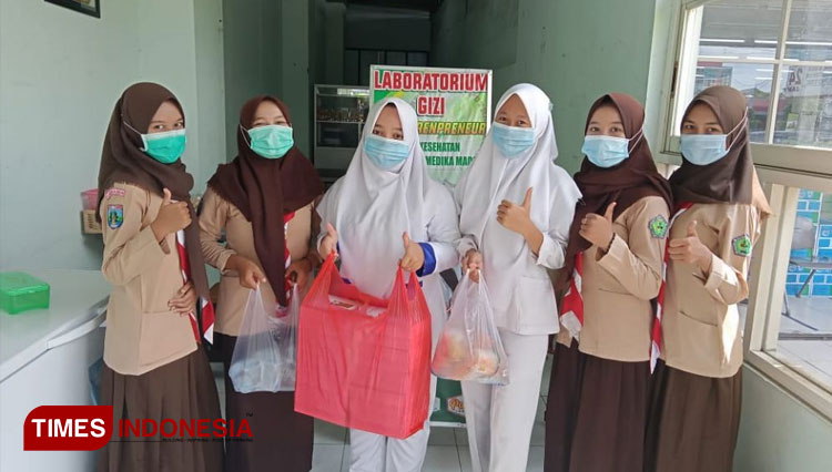 Kegiatan pembagian makanan siap saji oleh siswi-siswi kelas XI Jurusan Keperawatan dan Farmasi SMK Kesehatan Green Putra Medika Madiun. (Foto-foto: SMK Kesehatan Green Putra Medika for TIMES Indonesia)