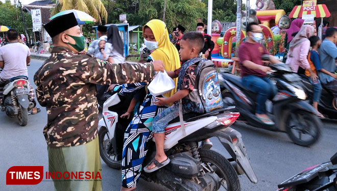 Pengurus Ansor beserta Banser saat bagikan takjil di kota santri Kecamatan Senori, Kabupaten Tuban (11/05/2020). (Foto: Ahmad Istihar/TIMES Indonesia)