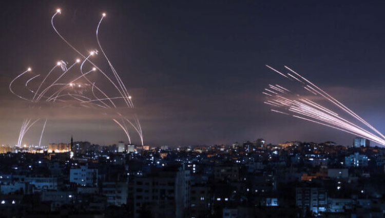 Roket dari Gaza (kanan) terlihat di langit malam ditembakkan ke Israel dari Beit Lahia di Jalur Gaza sementara rudal pencegat Iron Dome (kiri) muncul menghadangnya.(FOTO:The Times of Israel/AFPB.)