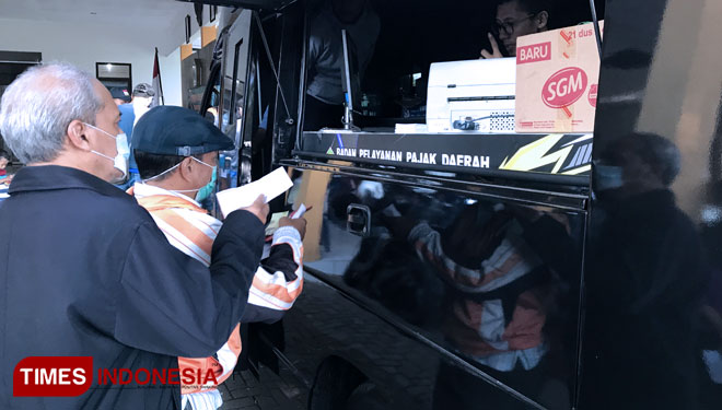Salah satu warga Mulyorejo saat melakukan pembayaran PBB di mobil yang telah disiapkan Bapenda di Kelurahan Mulyorejo, Kota Malang, Kamis (27/5/2021). (Foto: Rizky Kurniawan Pratama/TIMES Indonesia)