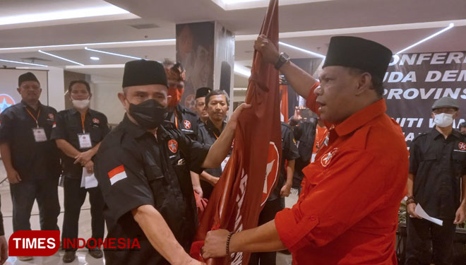 Ketum DPP Pemuda Demokrat Indonesia, Baharudin Farawowan (kanan), menyerahkan pataka Pemuda Demokrat kepada Ketua Pemuda Demokrat terpilih Heri Mei Oloan (kiri), saat Konferda ke IV DPD Pemuda Demokrat Indonesia Jabar di Kota Bandung, Minggu (30/5/21). (F