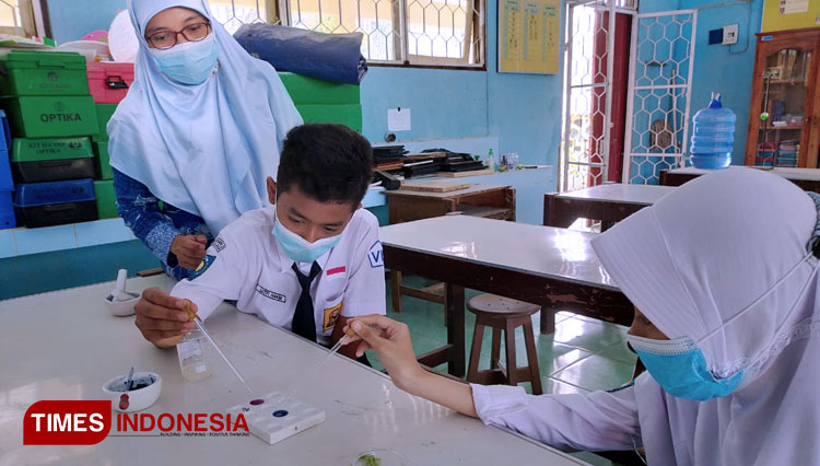 Siswa SMPN 2 Jeruklegi mengekstrak tanaman bunag Telang di laboratorium sekolah. (FOTO: Heni Purwono for TIMES Indonesia) 