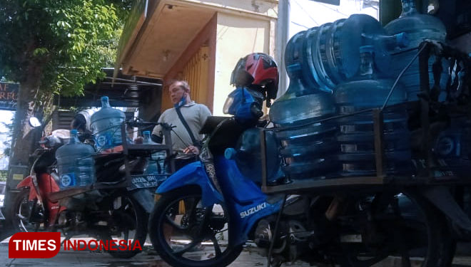 Proses pengiriman air minum isi ulang ke rumah-rumah warga yang memesan. Di tengah pandemi, konsumennya menurun hingga 50 persen (FOTO: Moh Bahri/TIMES Indonesia)
