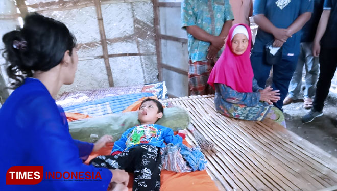 Moh Ashabul Kafi ditemani Ririn Fatmala Santi (ibunya) dan neneknya di gubuk yang ia huni.(Foto: Dicko W/TIMES Indonesia)