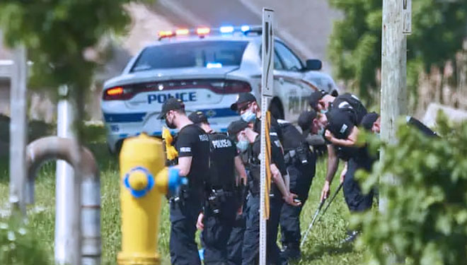 Petugas polisi saat mencari bukti di lokasi kecelakaan mobil di London, Ontario, Senin. (FOTO: Washington Post/The Canadian Press/AP)