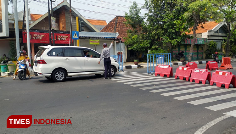 Petugas mengarahkan pengguna jalan untuk menggunakan jalur alternatif, karena arus lalu lintas di seputaran Alun-alun Lamongan dialihkan, Kamis (10/6/2021). (FOTO: MFA Rohmatillah/ TIMES Indonesia)