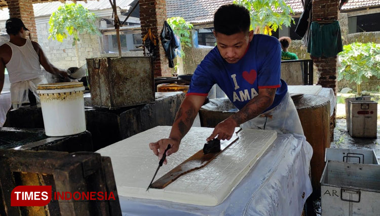 Seorang pekerja sedang memotong tahu di pabrik tahu milik Puji Sihono di Kelurahan Pakunden Kecamatan Sukorejo Kota Blitar, Jumat (11/6/2021). (Foto: Sholeh/TIMES Indonesia)