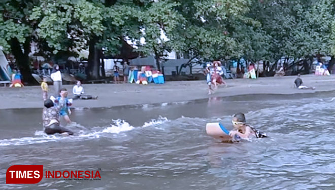 Wisatawan berenang di pantai Batukaras selain rekreasi juga ada yang sedang menjalani teraphy (Foto: Syamsul Ma'arif/TIMES Indonesia)