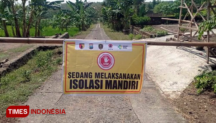 Jalan akses menuju Dusun Bulurejo, Desa Bantengan, Kecamatan Wungu, Kabupaten Madiun dipasang spanduk. (Foto: Romy Tri Setyo Wibowo/TIMES Indonesia)