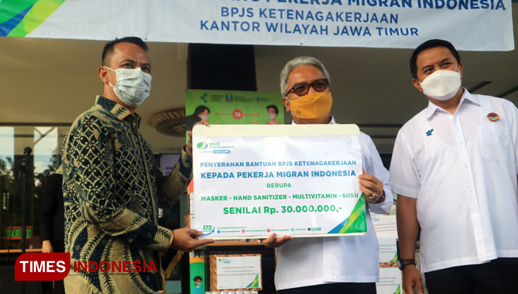 Deputi Direktur Wilayah BPJamsostek Jatim, Deny Yusyulian (kiri) bersama Kadisnakertrans Jatim Himawan Estu Bagijo (kanan) saat menyerahkan bantuan secara simbolis di Asrama Haji Sukolilo, Surabaya, Rabu (16/6/2021).(Foto : Lely Yuana/TIMES Indonesia)