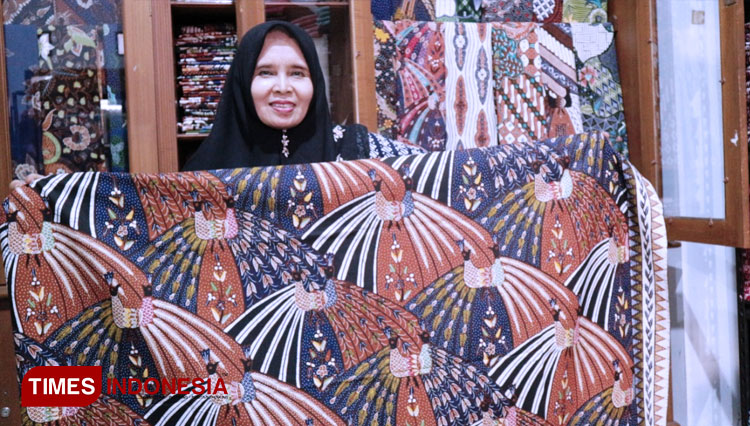 Pemilik Gerai Batik Agnesa di Jalan Ciroyom-Cigeureung, Kota Tasikmalaya, Hj Enok (56) memamerkan motif khas kebanggaannya, Merak Ngibing. (FOTO: Harniwan Obech/TIMES Indonesia)