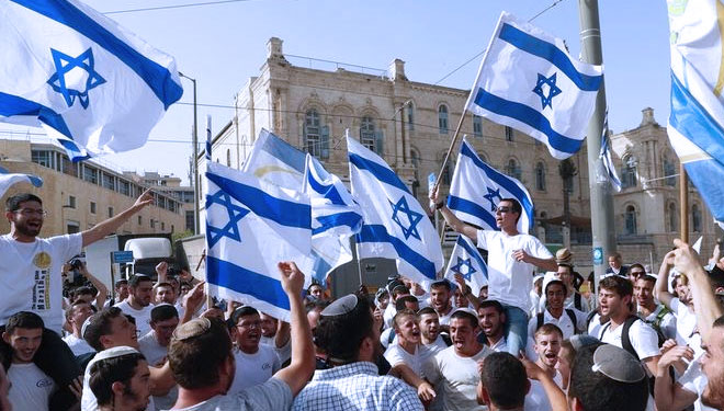 Dalam foto arsip 10 Mei 2021 ini, warga Israel mengibarkan bendera nasional selama parade Hari Yerusalem, di Yerusalem. (foto: AP PHOTO/ARIEL SCHALIT)