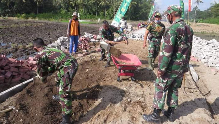 Prajurit TNI nampak tak kenal lelah mengerjakan pavingisasi di lokasi TMMD 111 Banyuwangi (Foto: Rizki Alfian/TIMES Indonesia)