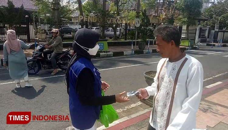 Wali Kota tampak duduk di trotoar untuk menghadang para jamaah salat Jumat di Masjid Agung yang tidak mengenakan masker (Foto: Susi/TIMES Indonesia)