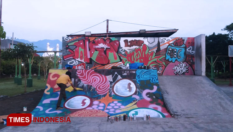Seniman Graffiti saat menuangkan karyanya di Skatepark. (FOTO: Dok. Junas for TIMES Indonesia)