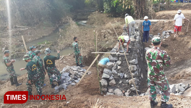 Para pasukan saat gotong royong membangun pondasi jembatan. (Foto : Rizki Alfian/ TIMESIndonesia)