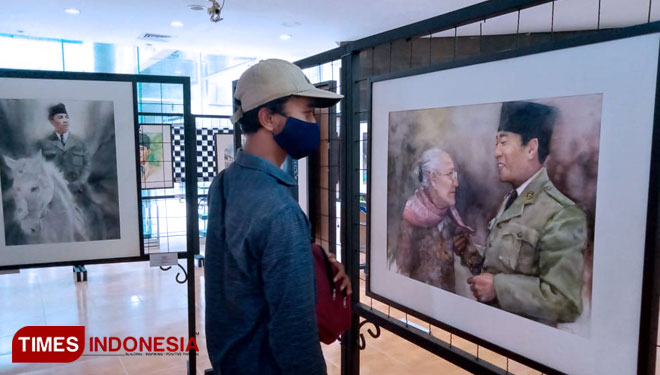 Seorang pengunjung sedang memperhatikan lukisan Bung Karno di pameran yang berlangsung di Perpustakaan Nasional Bung Karno, Minggu (20/6/2021). (Foto: Sholeh/ TIMES Indonesia)