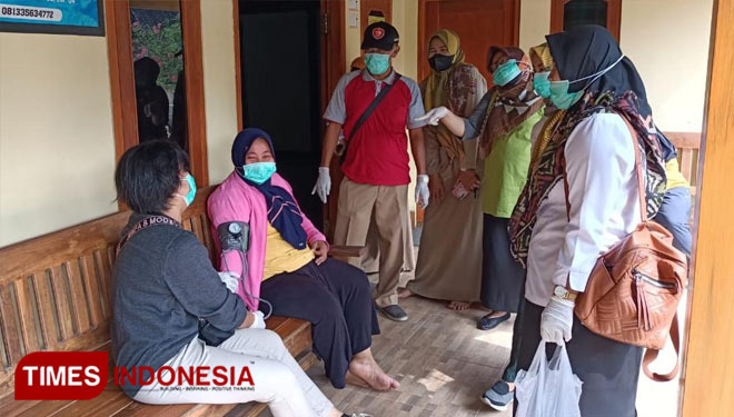 Petugas mengevakuasi warga yang diduga keracunan. (Foto: Dokumentasi Sekdes Sukowiyono for TIMES Indonesia)