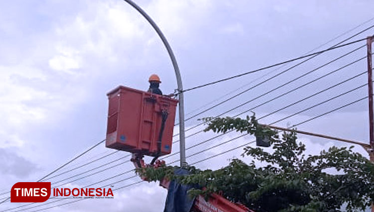 Petugas Dishub Gresik saat memperbaiki aliran listrik penerangan jalan umum (PJU) (FOTO: Akmal/TIMES Indonesia)
