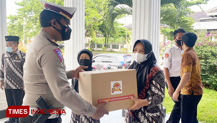 Personel Polres Majalengka menyerahkan paket sembako kepada warga. (Foto: Jaja Sumarja/TIMES Indonesia)