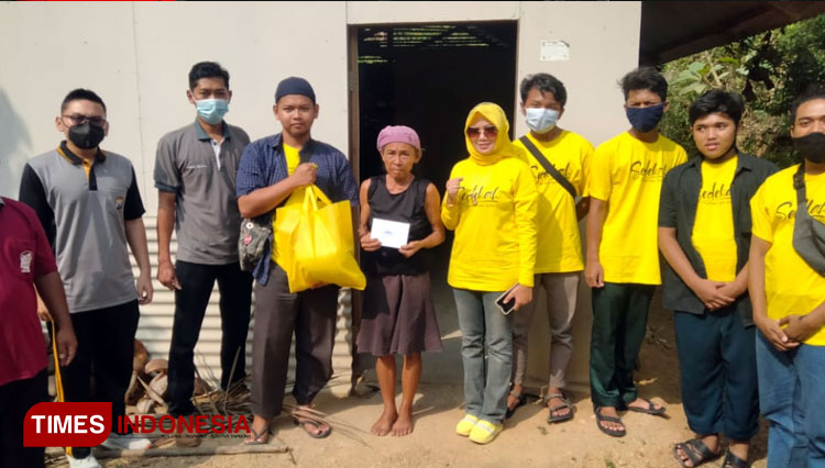 Baju Kuning kru dari Rumah Sedekah Pacitan saat memberikan paket sembako kepada warga kurang mampu (Foto: Atik Lia Estin For TIMES Indonesia)