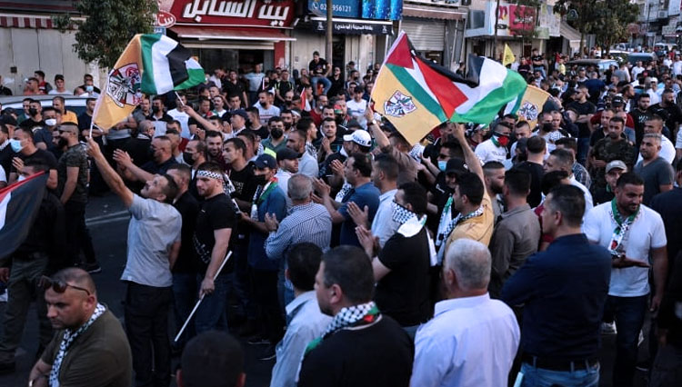 Warga Palestina yang berdemonstrasi di Ramallah, memprotes kematian Nizar Banat. (FOTO: Al Jazeera/AFP)