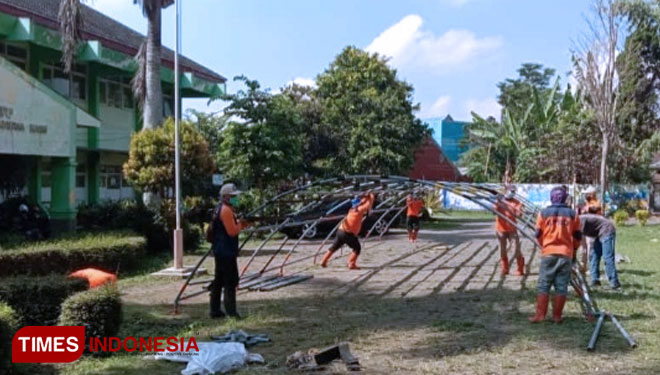 Petugas BPBD memasang tenda darurat di halaman parkir Puskesmas Batu hari ini untuk memberikan kenyamanan kepada masyarakat. (foto: Muhammad Dhani Rahman/TIMES Indonesia)