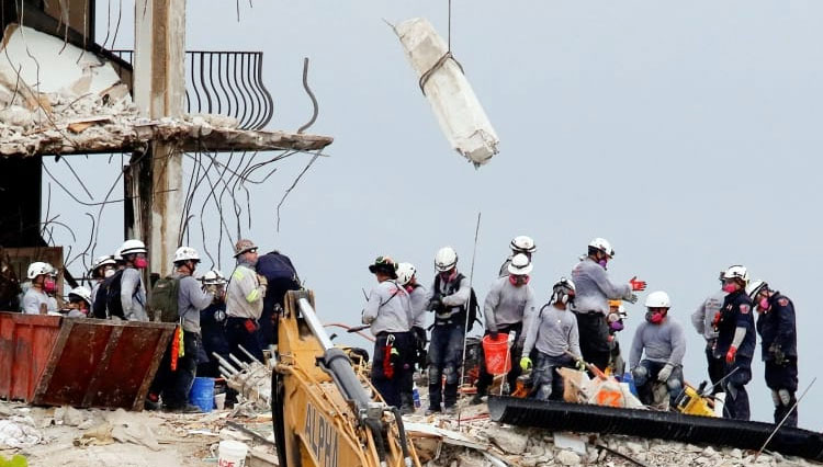 Pekerja darurat melakukan upaya pencarian dan penyelamatan di lokasi bangunan tempat tinggal yang sebagian runtuh di Surfside, dekat Miami Beach, Florida, pada 30 Juni 2021. (FOTO: Al Jazeera/Reuters)