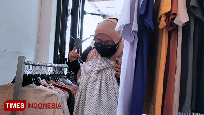 Pengunjung tetap memperhatikan protokol kesehatan Covid-19 saat memilih baju di SHELLYNATION SECONDBRAND. (Foto: Naufal Ardiansyah/TIMES Indonesia)