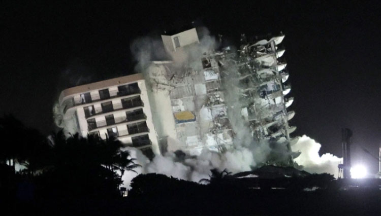 Bagian gedung kondominium Champlain Towers South 12 lantai akhirnya dirobohkan, Minggu (4/7/2021) malam karena kondisi yang mengkhawatirkan dan akan datangnya Badai Tropis Elsa. (FOTO: Al Jazeera/Getty Image/AFP)