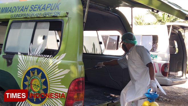 Petugas saat melakukan penyemprotan disinfektan ke ambulans. (Foto: Akmal/TIMES Indonesia).