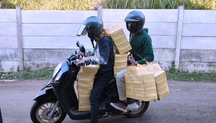Petugas saat mengantarkan makanan siap saji untuk pasien Covid-19 yang sedang melakukan isolasi mandiri. (Foto: Dok. Relawan Cak Udin for TIMES Indonesia)