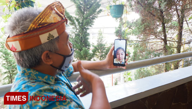 Ketua Panitia MPLS SMPK Santa Maria 2 Malang, Trianto, saat berinteraksi dengan salah satu peserta MPLS lewat ponsel pintarnya. (Foto: Naufal Ardiansyah/TIMES Indonesia)