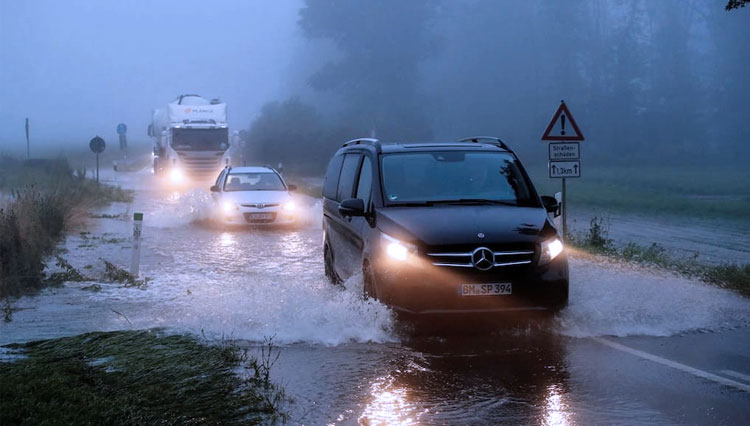 Kendaraan melewati jalan yang terkena banjir setelah sungai Erft meluap menyusul hujan deras di Erftstadt, dekat Cologne, Jerman, 15 Juli 2021. (FOTO: Reuters)