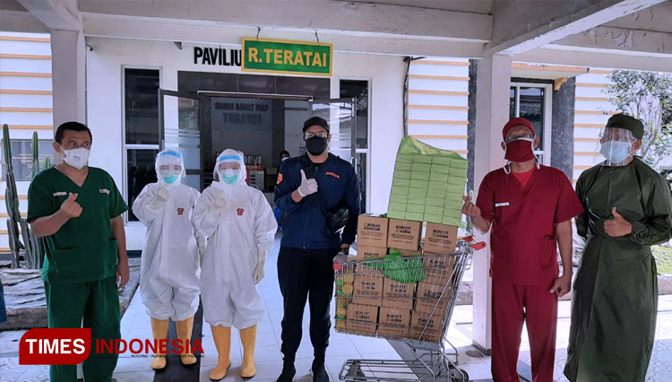Owner Jamu Cacak, Mohammad Aindra Imawan (tengah), saat memberikan jamu untuk para Nakes di RSUD dr. Soegiri Lamongan. (FOTO: MFA Rohmatillah/ TIMES Indonesia)