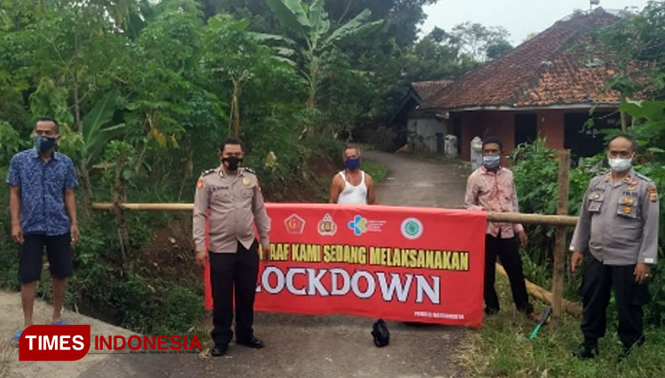 Spanduk terbentang bertuliskan Maaf Kami Sedang Melaksanakan Lockdown melintas jalan desa menuju kampung Sukamulya, Desa Margamulya, Kecamatan Sukaresik, Kabupaten Tasikmalaya. (FOTO : Dok. Humas Polres Tasikmalaya Kota/TIMES Indonesia)