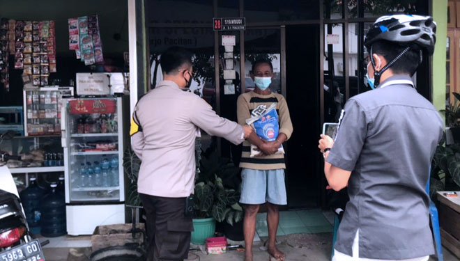 Kapolres Pacitan, AKBP Wiwit Ari Wibisono tampak berikan paket sembako dan uang disela-sela ingatkan prokes pada pedagang (Foto: Rojihan/TIMES Indonesia)