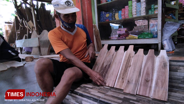 Sukatman lagi mengerjakan kerajinannya memanfaatkan limbah kayu di jadikan alat dapur parut (FOTO: Yusuf For TIMES Indonesia)