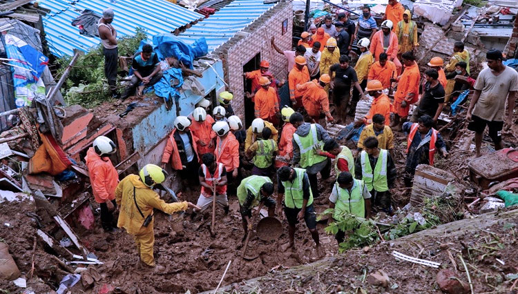 Petugas penyelamat mencari korban selamat setelah rumah warga roboh akibat longsor akibat hujan deras di Mumbai, India, 18 Juli 2021. (FOTO: Reuters)