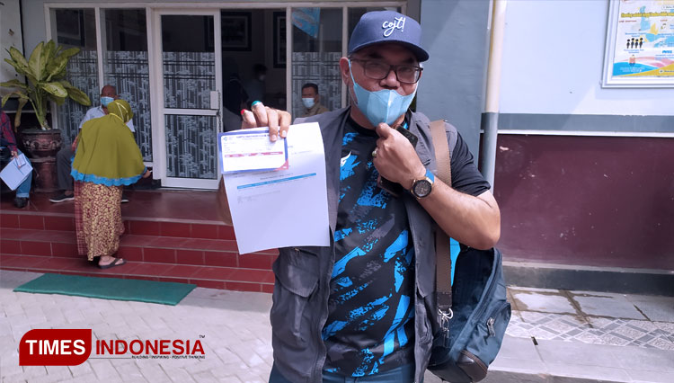 Pelatih Persela Lamongan, Iwan Setiawan menunjukkan kartu vaksin Covid-19, setelah menjalani vaksinasi di Dinkes Lamongan, Kamis (22/7/2021). (FOTO: MFA Rohmatillah/ TIMES Indonesia)