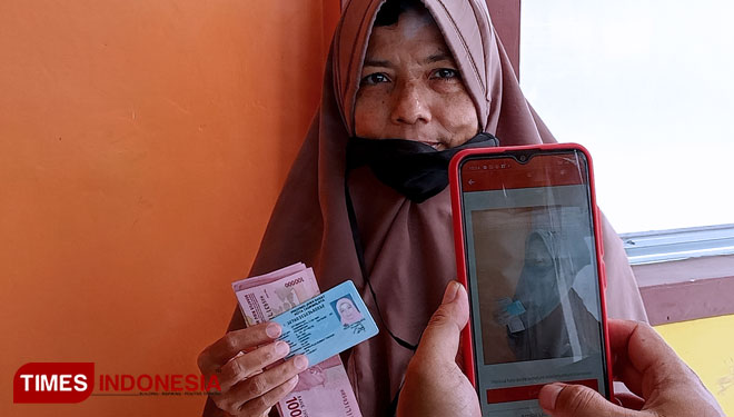 Seorang ibu warga Kahuripan Tawang Tasikmalaya, difoto dengan memperlihatkan sejumlah uang dan KTP sebagai syarat administrasi pencairan BST, Kamis (22/7/21) siang (FOTO: Harniwan Obech/TIMES Indonesia)