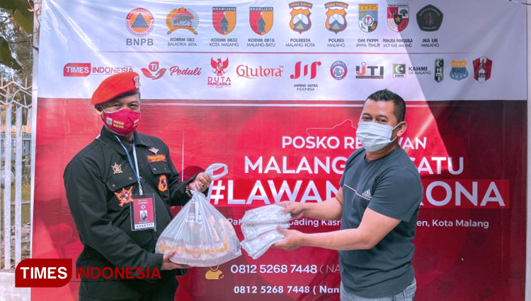 Relawan MBLC menyerahkan bantuan paket sembako dan masker kain kepada perwakilan warga Ngijo Karangploso kabupaten Malang. (FOTO: MBLC/TIMES Indonesia)