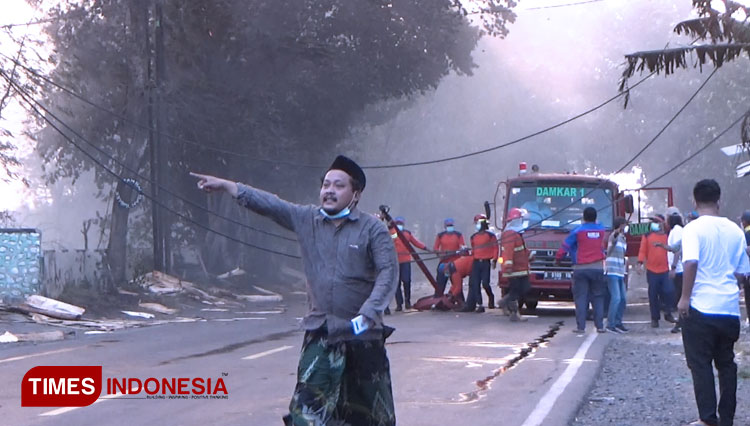 Kabel PLN yang mengarah ke pabrik kayu yang terbakar melintang di tengah jalan. (FOTO: Happy/TIMES Indonesia)