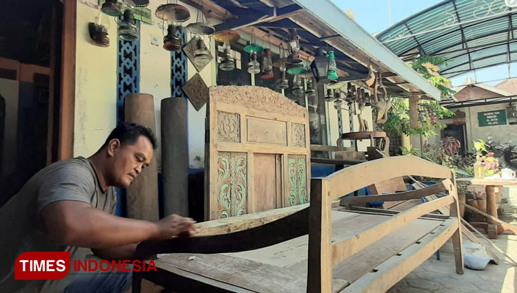 Andik Priyo, warga Jetis, Ponorogo membersihkan risban kuno di halaman rumahnya. (Foto: Bambang H Irwanto/TIMES Indonesia)