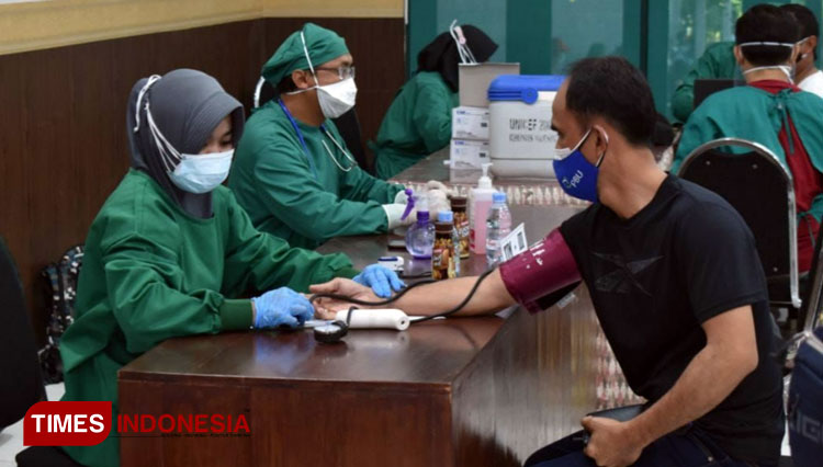 Tenaga kesehatan di Banyuwangi sedang melakukan vaksinasi Covid-19. (FOTO: Agung Sedana/ TIMES Indonesia)