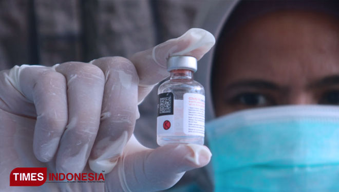 Seorang tenaga kesehatan menunjukkan satu dosis vaksin Covid-19. (FOTO: dok. Times Indonesia)