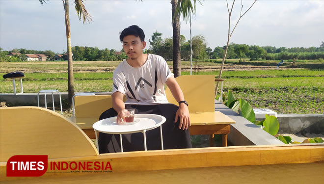 Salah satu pengunjung yang sedang menikmati ngopi sensasi sawah di Cafe Konoa (Foto:  Rohmadi/TIMES Indonesia)
